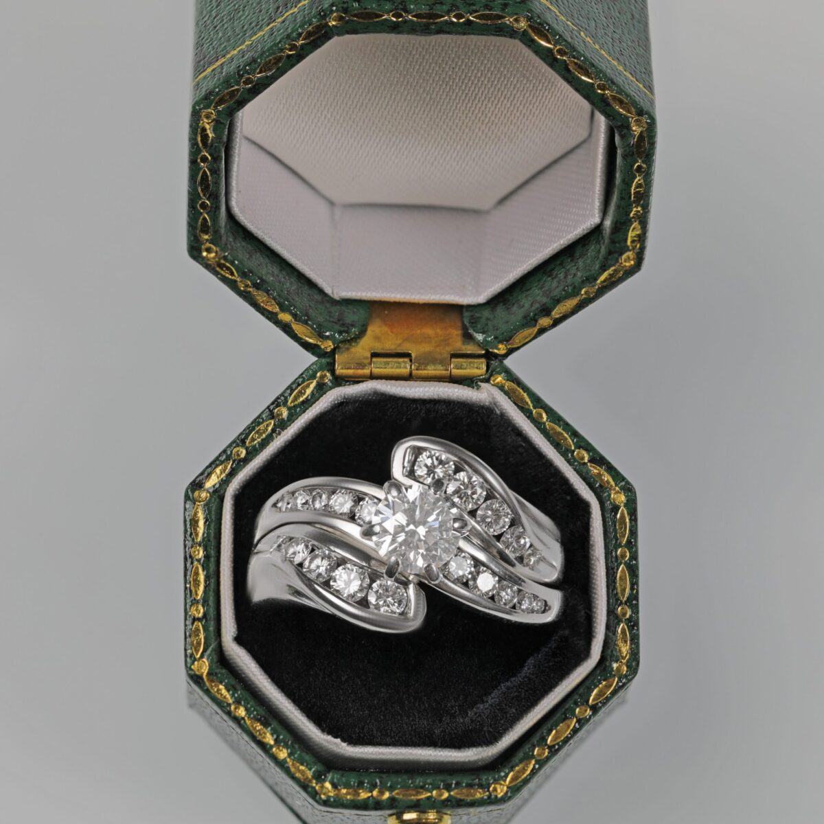 Custom 14K white gold diamond wedding ring set displayed in a green ring box featuring a brilliant center diamond with channel set accent diamonds, custom made in Northern California