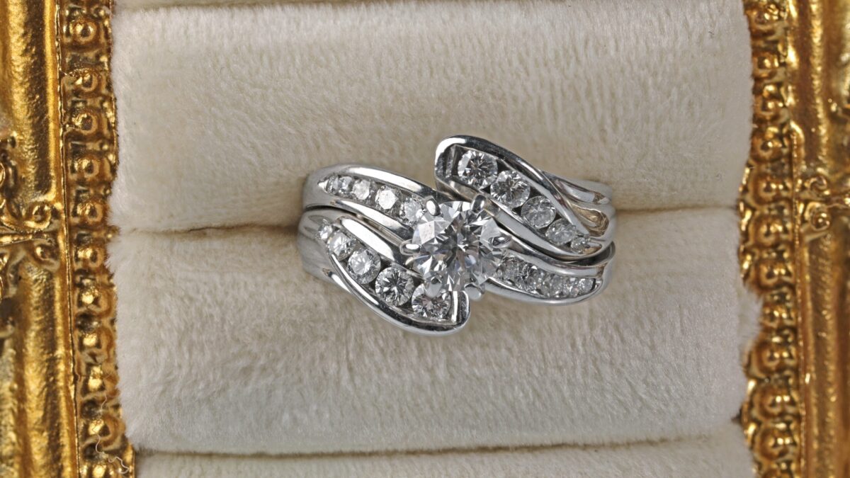 Custom 14K white gold diamond wedding ring displayed in a jewelry frame featuring a brilliant center diamond with channel set accent diamonds, custom made in Northern California