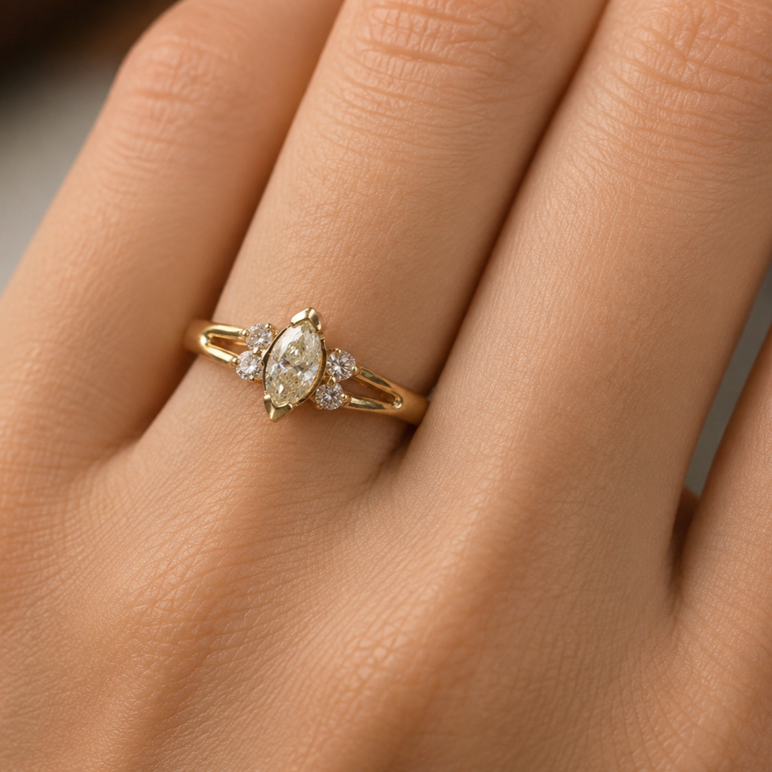 Hand wearing a 14K yellow gold marquise diamond ring featuring a 0.45 carat marquise cut center diamond accented by four round brilliant side diamonds in a classic vintage-inspired design.